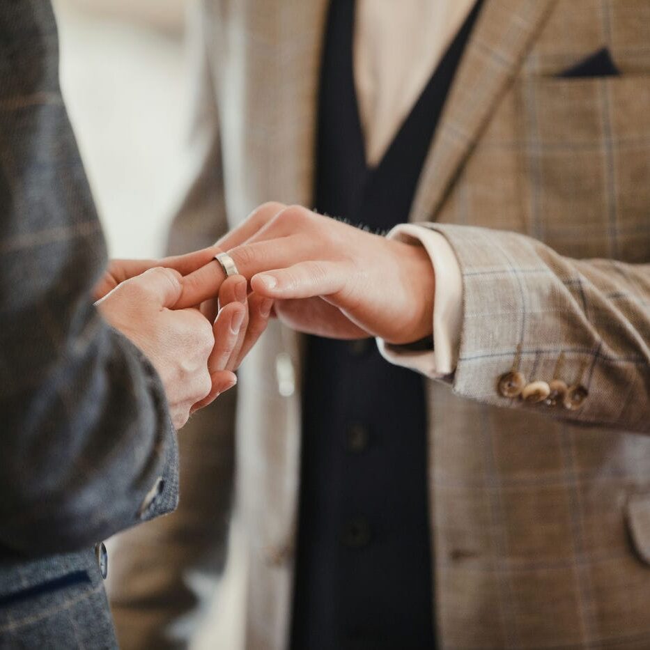 lgbtq couple putting rings on